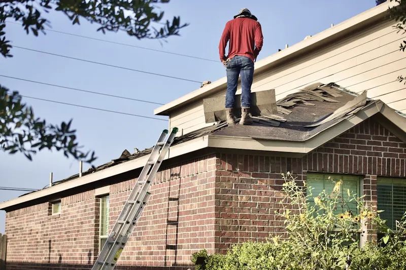 Professional roofer working on a residential roof in Sharp